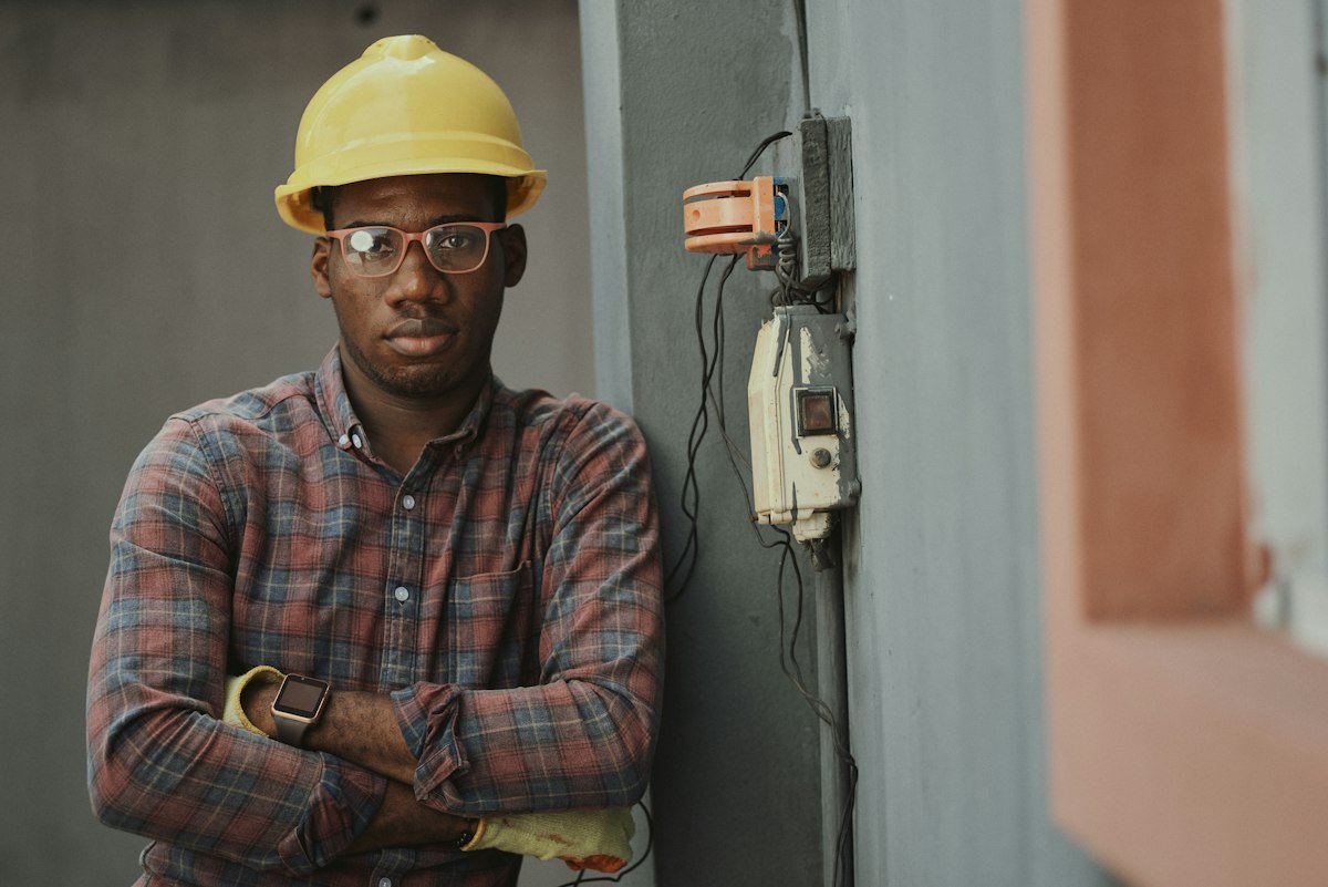 Electrician standing beside an electrical enclosure