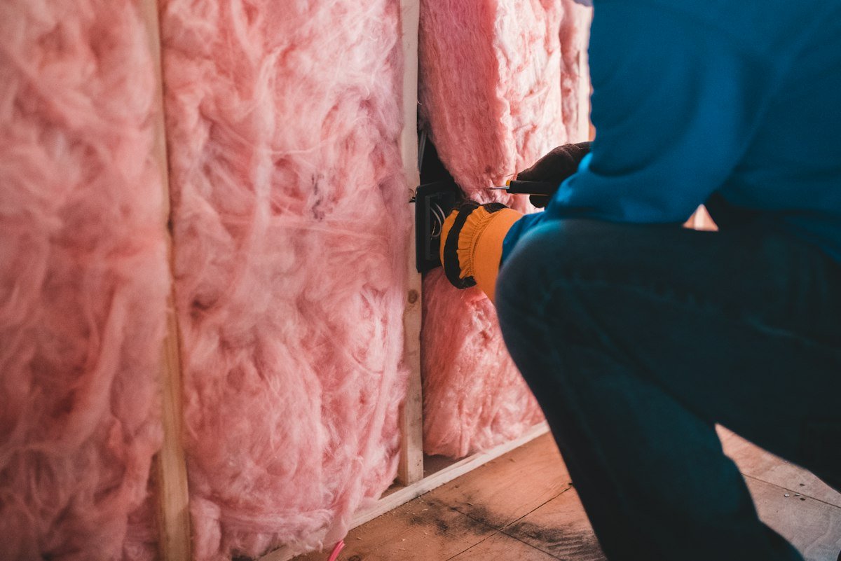 Electrician wiring a back box in a stud wall